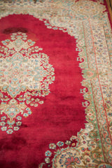 Plush cochineal red Kerman rug field with visible color variation and ornate floral motifs.
