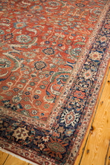 Antique Fereghan carpet with rich rust field and detailed navy blue botanical border.