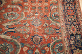 Antique Fereghan carpet with intricate blue, green, gold floral vine motifs.