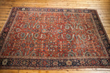 Late 19th century Fereghan carpet, earth tone rust field, allover floral design, dark blue border.