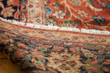 Intricate hand-knotted foundation of an antique Fereghan rug with patterned borders and white fringe.