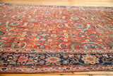 Antique Fereghan carpet: earthy rust field with dense blue, green florals, and navy border.