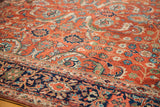 Intricate curvilinear designs in saturated greens, blues, and rust on an antique Fereghan rug.