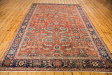 Bottom corner of an Antique Fereghan carpet: rust field, intricate floral design, deep blue border, fringe.