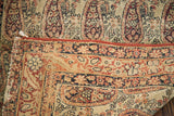 Worn antique Lavar Kerman rug, detailing red overcast edge and faded Paisley boteh pattern.
