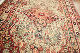 Angular red, blue, and cream motifs of the antique Kerman rug's central medallion.
