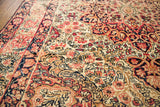 Blanched ivory, red, and navy floral patterns with softened pile on an antique Kerman rug.