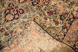 Late 19th century Kerman rug's hand-knotted foundation, blanched floral motifs, and fringe.