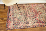 Faded red and navy floral patterns with blanched pile on an antique Kerman rug section.