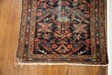 Vintage Lilihan rug corner with worn deep blue field, geometric motifs, and fringe.