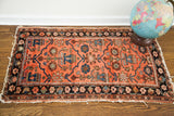 Worn fringed edge of a vintage Persian Lilihan rug corner with dark floral border.