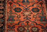 Aged red field with stylized blue, maroon, and green floral motifs on a vintage Lilihan rug.