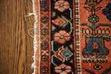Worn texture and bold floral motifs in blue and red on a vintage Lilihan rug.
