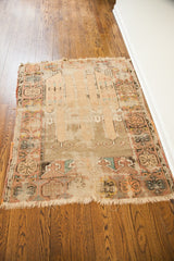 Antique Turkish prayer rug's tattered pile, blanched aesthetic, and frayed fringe.