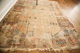 Blanched geometric patterns and heavily tattered fringe on the antique Turkish prayer rug.