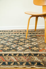 Dark blue and beige geometric patterns with pink accents on an aged antique Caucasian rug.