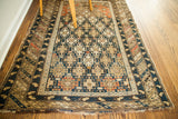 Antique Caucasian rug: worn geometric tribal patterns in natural dark blue, beige, and orange.