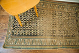 Geometric antique Caucasian rug with hard wear, revealing faded blues and ivories.