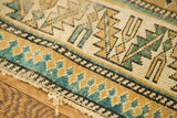 Hard wear and geometric pattern in teal, gold, and charcoal on this antique Caucasian rug.