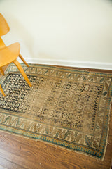 Antique Caucasian rug detail showing hard wear, faded blue, yellow, and charcoal geometric patterns.