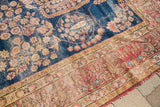 Section of antique Kerman rug; distressed dark blue field, weeping willow motif, and elaborate floral borders.