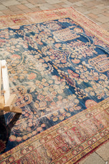 Distressed dark blue field featuring an intricate weeping willow motif on this antique Kerman carpet.