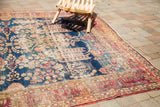 Antique Kerman rug's dark blue field, weeping willow motif, and traditional red border with patina.