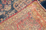 Antique Kerman rug corner, featuring intricate red border and blue weeping willow field.