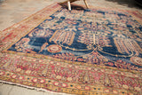 Antique Kerman carpet's red border with paisley motifs, and dark blue weeping willow field section.