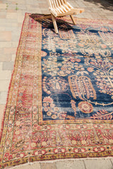 Distressed dark blue field, weeping willow motif, and red, ivory Kerman rug borders.