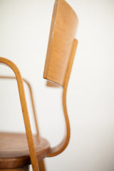 Curved bent plywood backrest of Thonet chair, with natural patina and small chip.