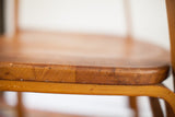 Vintage Thonet bent plywood chair seat edge, with visible wood grain and aged patina.
