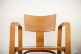 Vintage Thonet bent plywood chair's curved armrest and backrest edge with a small chip.