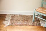 Vintage Afghani rug mat with subtle geometric pattern in silver grey and earth tones.