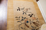 Antique Chinese Nichols rug showing a pale yellow border, thick cream pile, and Art Deco floral vines.