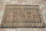 Antique Caucasian rug border with geometric stripes in light blue, beige, and brown.