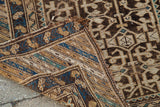 Folded antique Caucasian rug corner, revealing hand-knotted tribal geometric patterns and blue.