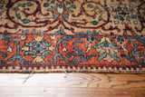 Tattered red border with blue scrolling motifs on a vintage Tabriz mat, circa 1930.