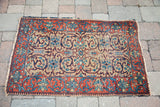 Distressed corner of vintage Persian Tabriz rug, with coral border and gold scrolling motifs.