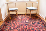 Traditional Persian Lilihan rug's raspberry red field, blue willow motifs, and charming wear.