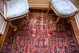 Vintage Persian Lilihan rug; raspberry red field, dark blue willow tree motifs, and patina.