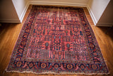 Fringed lower corner of a vintage Lilihan rug with navy floral border and raspberry field willow trees.