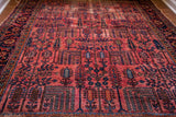 Vintage Lilihan rug showing raspberry red field, blue willow tree motifs, and unique textural wear.