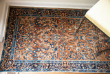 Deep gold field with curvilinear blue and ivory floral motifs on a vintage Yezd rug.