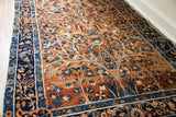Persian Yezd rug with deep gold field, blue tree-of-life design, and intricate navy border motifs.