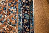 Intricate bird motif on antique Yezd rug's deep gold field and navy border.