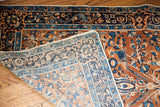 Folded vintage Persian Yezd rug displays deep gold pile, blue motifs, and intricate reverse weave.