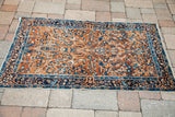 Navy border on the antique Persian Yezd rug, with blue floral forms and bird designs.