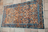 Curvilinear blue and gold floral patterns with bird motifs on the Yezd rug.