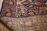 Antique Kerman rug's folded corner, showing rich floral pile and subtle coloring on reverse.